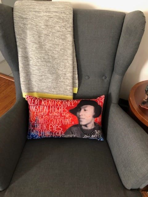 Zora Neale Hurston Pillow on chair with throw. Lumbar pillow with vibrant red color and marker-like writings.  Prominent face of Zora with hat. Small indoor outdoor pillow. Most comfortable couch pillow, vintage throw pillow 
